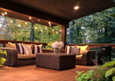 A Cozy Wooden Deck with Wicker Furniture and Ambient Lights in Menasha, WI